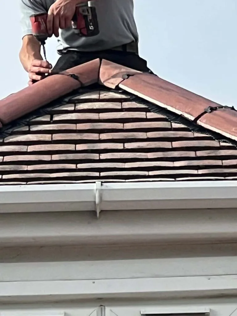 This is a photo of one of the operatives of MCM Roofing Repairs Shaftesbury installing new ridge tiles